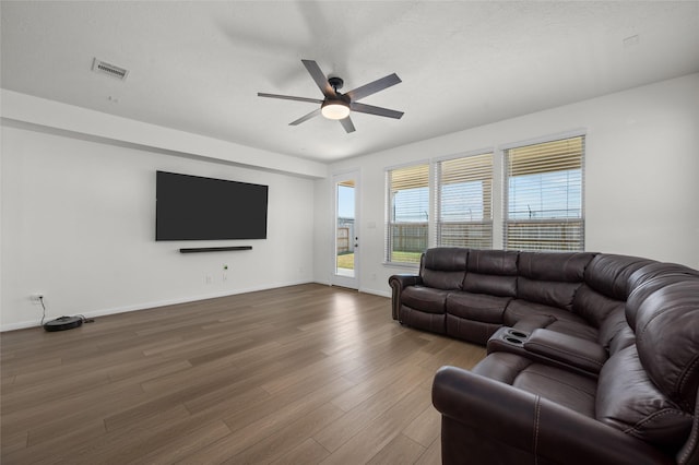 living room with wood finished floors, baseboards, a ceiling fan, and visible vents