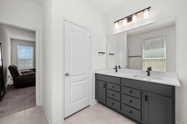 ensuite bathroom with a sink, double vanity, connected bathroom, and tile patterned flooring