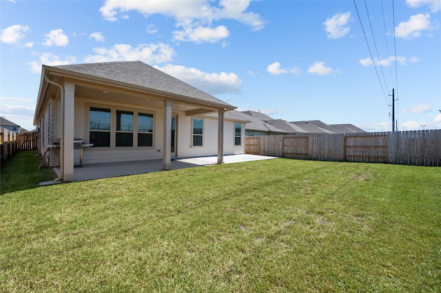 rear view of house with a yard and a patio area