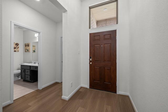 foyer with wood finished floors and baseboards