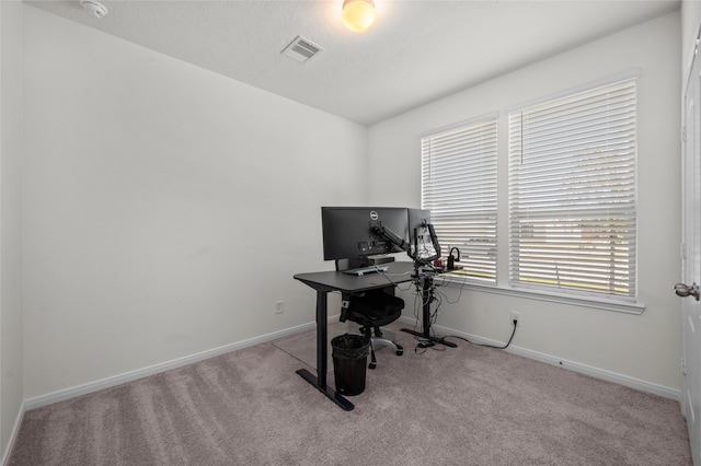 carpeted office space with visible vents and baseboards