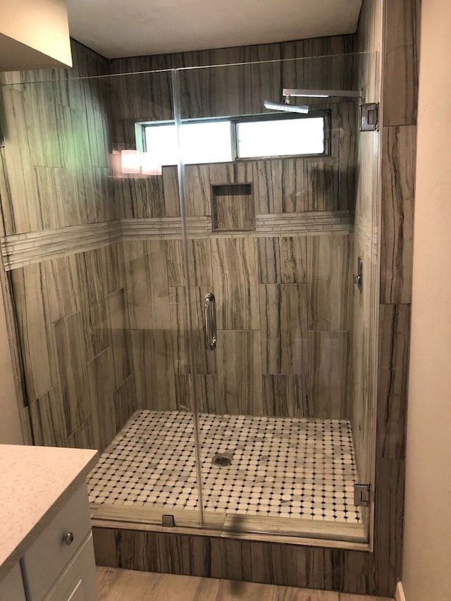 bathroom featuring vanity, a shower with shower door, and hardwood / wood-style floors