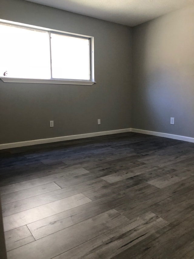 unfurnished room with dark hardwood / wood-style floors