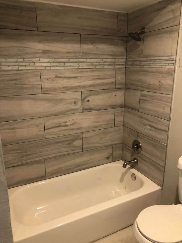 bathroom with tiled shower / bath combo and toilet