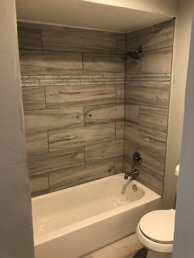 bathroom with tiled shower / bath and toilet