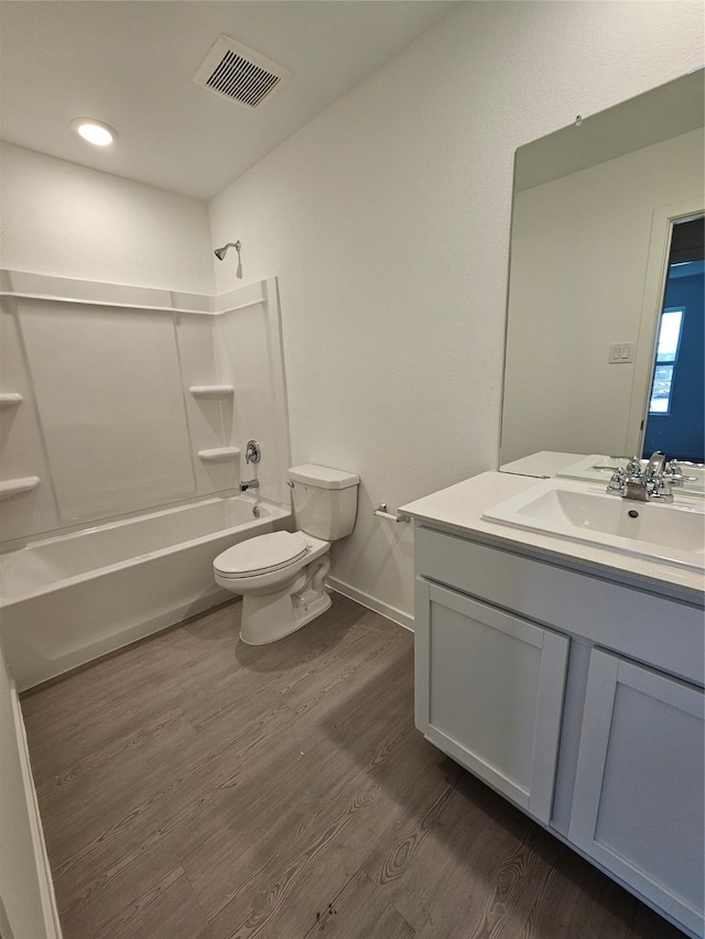 full bathroom with shower / bathing tub combination, hardwood / wood-style floors, vanity, and toilet