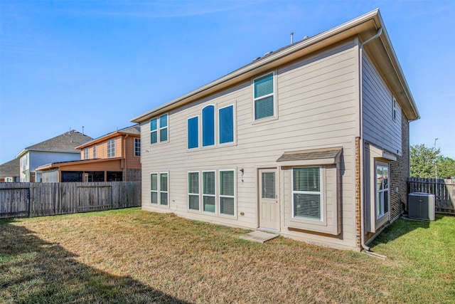 back of property with a lawn and central AC