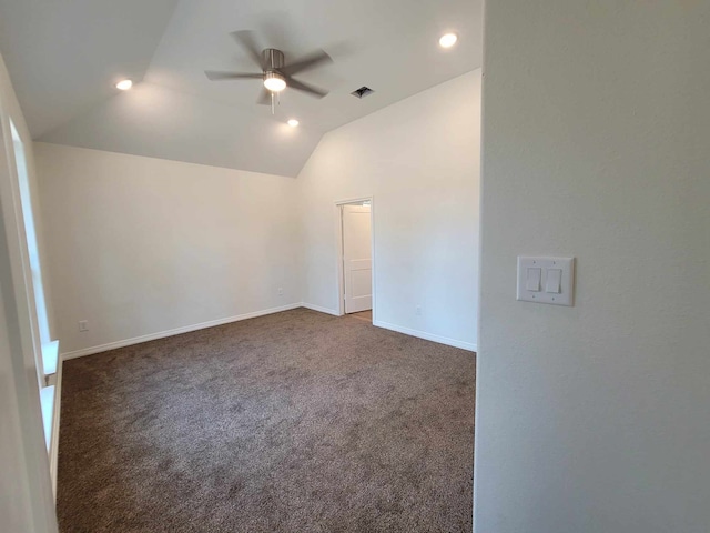 spare room with lofted ceiling, dark colored carpet, and ceiling fan