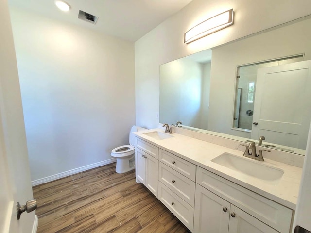 bathroom featuring toilet, hardwood / wood-style floors, and vanity