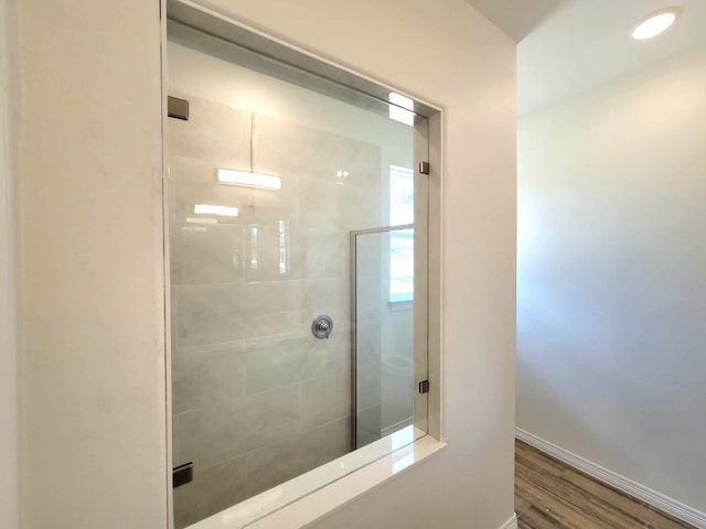 bathroom featuring a shower with door and wood-type flooring