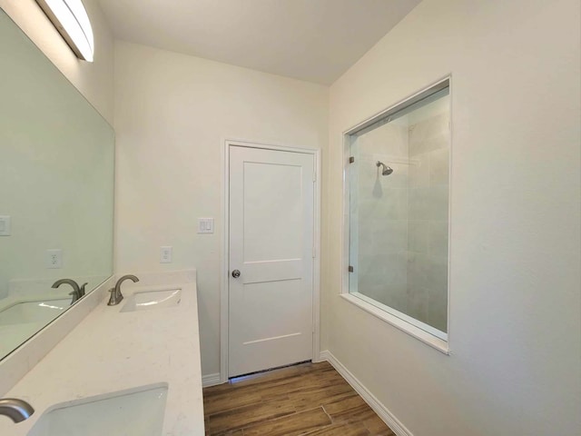 bathroom featuring vanity, hardwood / wood-style floors, and a tile shower