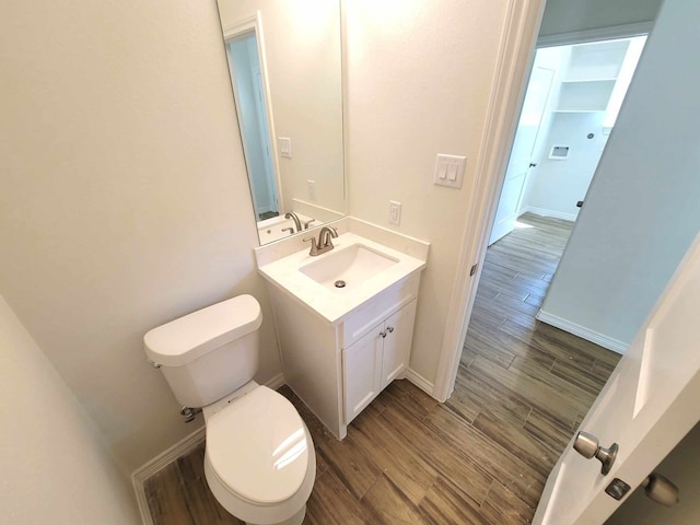 bathroom featuring vanity, hardwood / wood-style flooring, and toilet