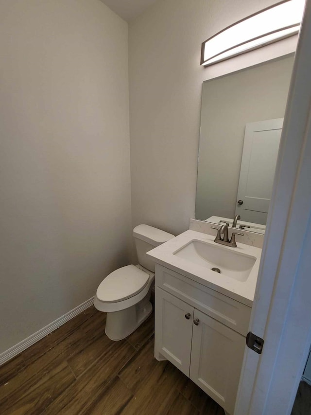 bathroom with vanity, hardwood / wood-style floors, and toilet