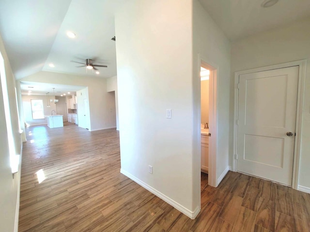 corridor featuring lofted ceiling and dark wood-type flooring