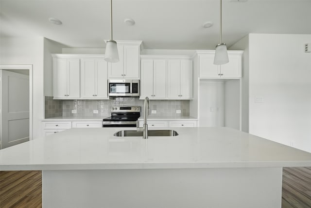 24644 Cavan St, Hempstead, TX 77445 - kitchen with appliances with stainless steel finishes, a sink, dark wood-style floors, an island with sink, and tasteful backsplash
