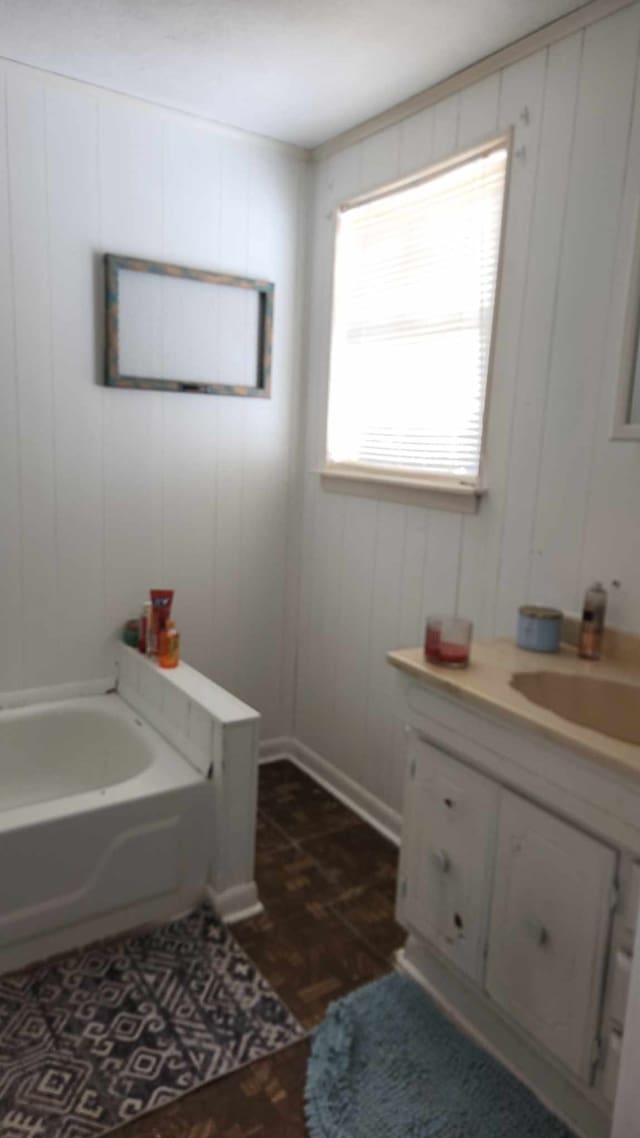 bathroom featuring vanity, hardwood / wood-style flooring, and a tub