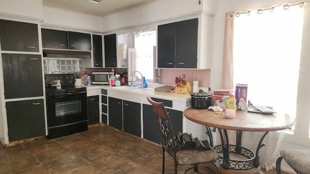 kitchen featuring black electric range oven, sink, and tasteful backsplash