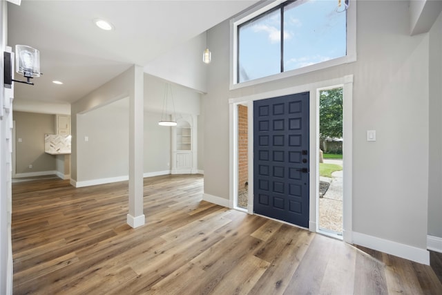 foyer featuring wood-type flooring and a towering ceiling