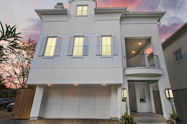 view of front of property featuring a balcony and a garage