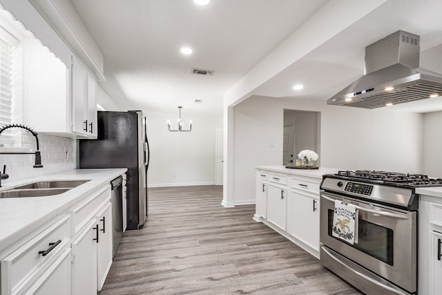 kitchen with light hardwood / wood-style floors, sink, white cabinets, wall chimney exhaust hood, and appliances with stainless steel finishes