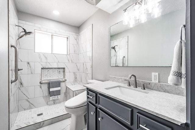 bathroom featuring vanity, toilet, and tiled shower