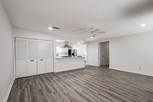 interior space with a textured ceiling, dark hardwood / wood-style floors, ceiling fan, and sink