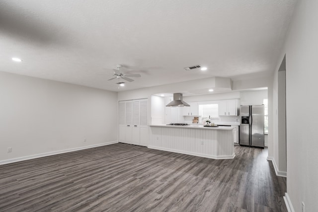 unfurnished living room featuring ceiling fan, a textured ceiling, and dark wood-type flooring