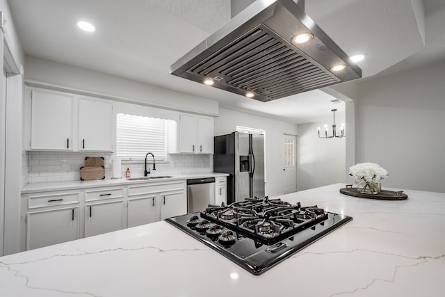 kitchen with sink, island exhaust hood, white cabinetry, appliances with stainless steel finishes, and decorative backsplash