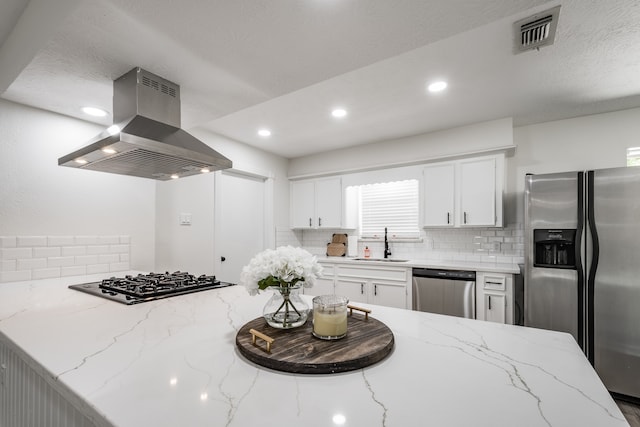 kitchen with appliances with stainless steel finishes, white cabinetry, island range hood, kitchen peninsula, and sink