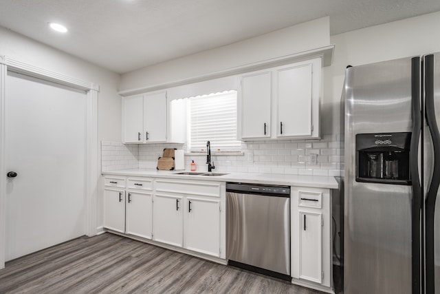 kitchen with appliances with stainless steel finishes, white cabinetry, and sink