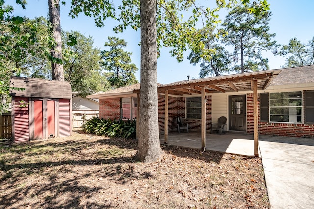 back of property with a storage unit and a patio