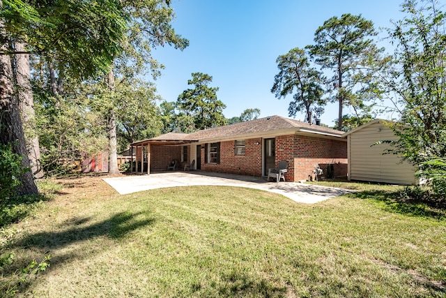 rear view of house with a lawn and a patio