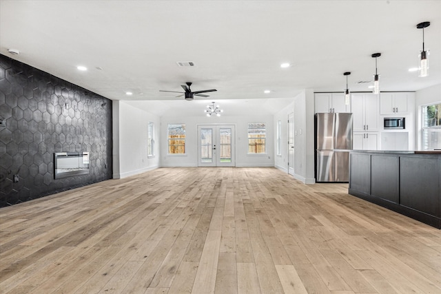 unfurnished living room featuring light wood-type flooring, ceiling fan, and a fireplace