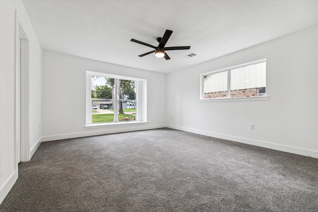 spare room with ceiling fan and dark colored carpet