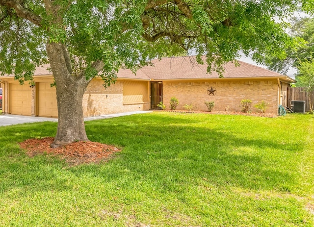 ranch-style house with a front yard, a garage, and cooling unit