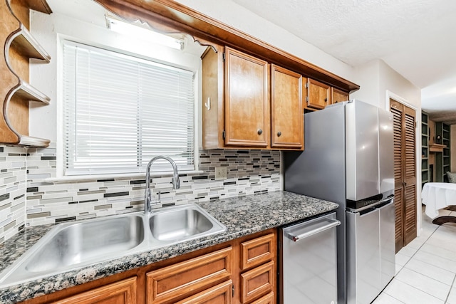 kitchen with decorative backsplash, light tile patterned flooring, sink, and appliances with stainless steel finishes