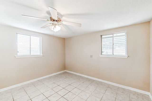 spare room with light tile patterned flooring, plenty of natural light, and ceiling fan