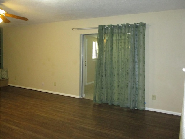 empty room with dark hardwood / wood-style floors and ceiling fan