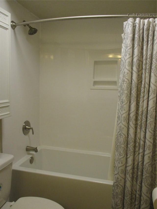 bathroom with shower / bath combo with shower curtain and toilet