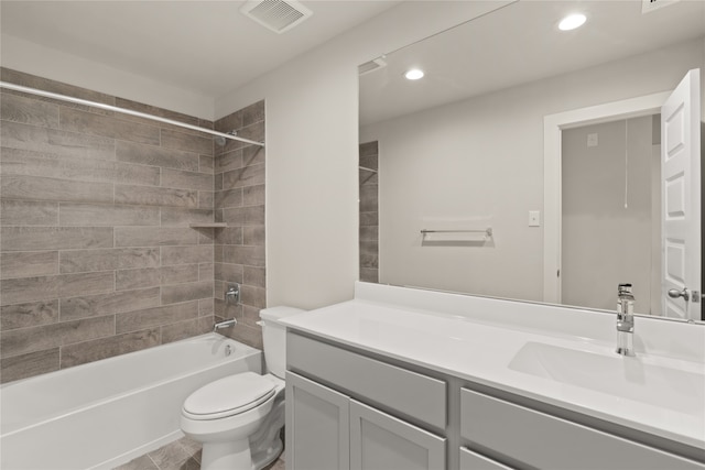 full bathroom featuring tiled shower / bath, vanity, and toilet