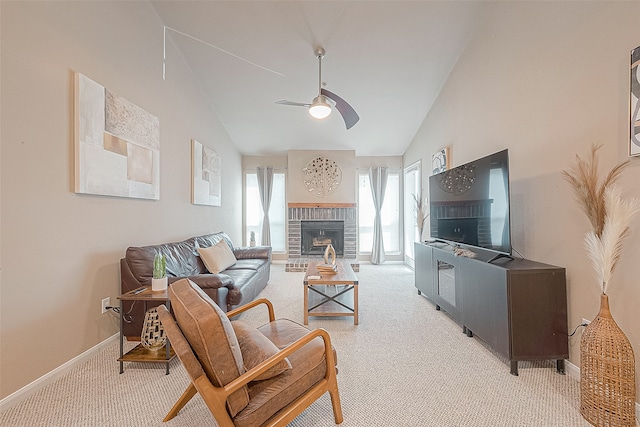 carpeted living room featuring a fireplace, vaulted ceiling, and ceiling fan