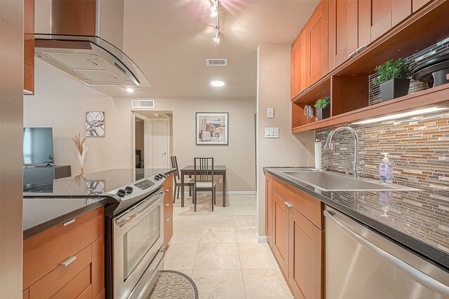 kitchen featuring light tile patterned flooring, stainless steel appliances, sink, and decorative backsplash