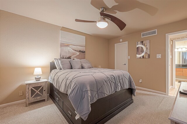 carpeted bedroom featuring ceiling fan and ensuite bathroom