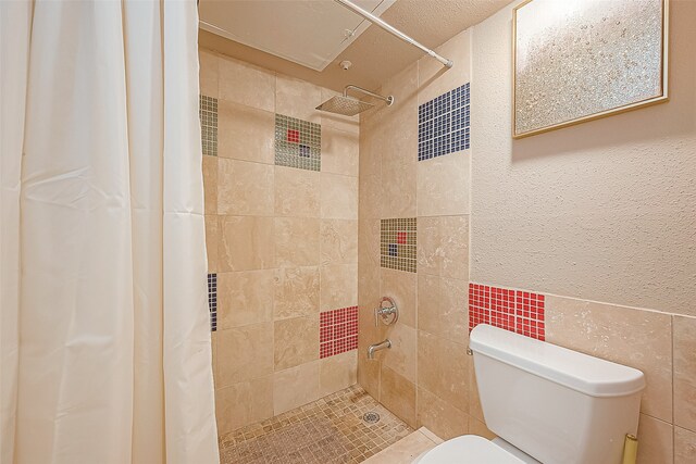 bathroom featuring a shower with curtain, tile walls, and toilet