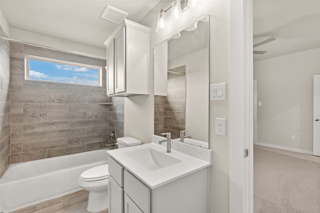 full bathroom with toilet, hardwood / wood-style floors, tiled shower / bath, vanity, and ceiling fan