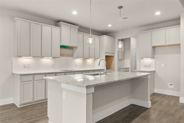 kitchen featuring an island with sink and white cabinetry