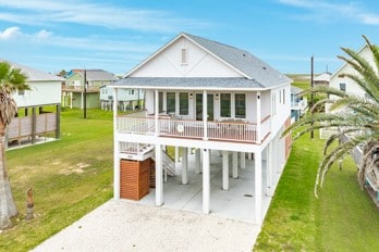 back of property featuring a carport and a lawn