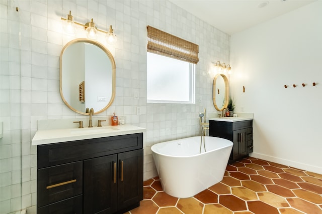 bathroom with tile walls, tile patterned flooring, a bath, and vanity