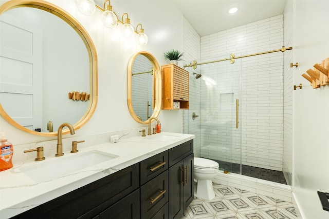 bathroom featuring toilet, vanity, and a shower with door