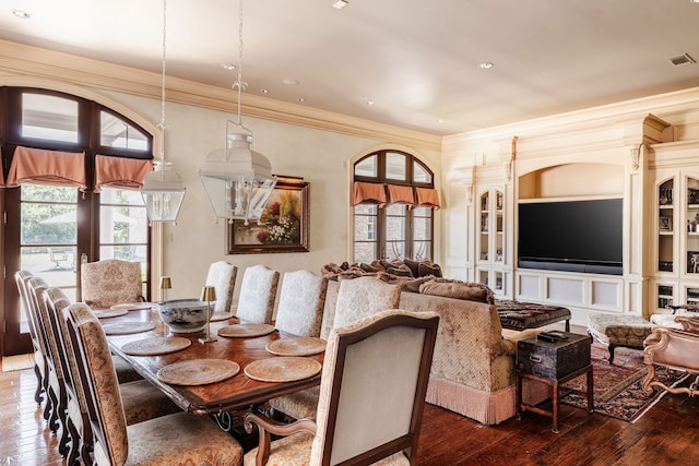 dining space featuring ornamental molding, decorative columns, and hardwood / wood-style flooring